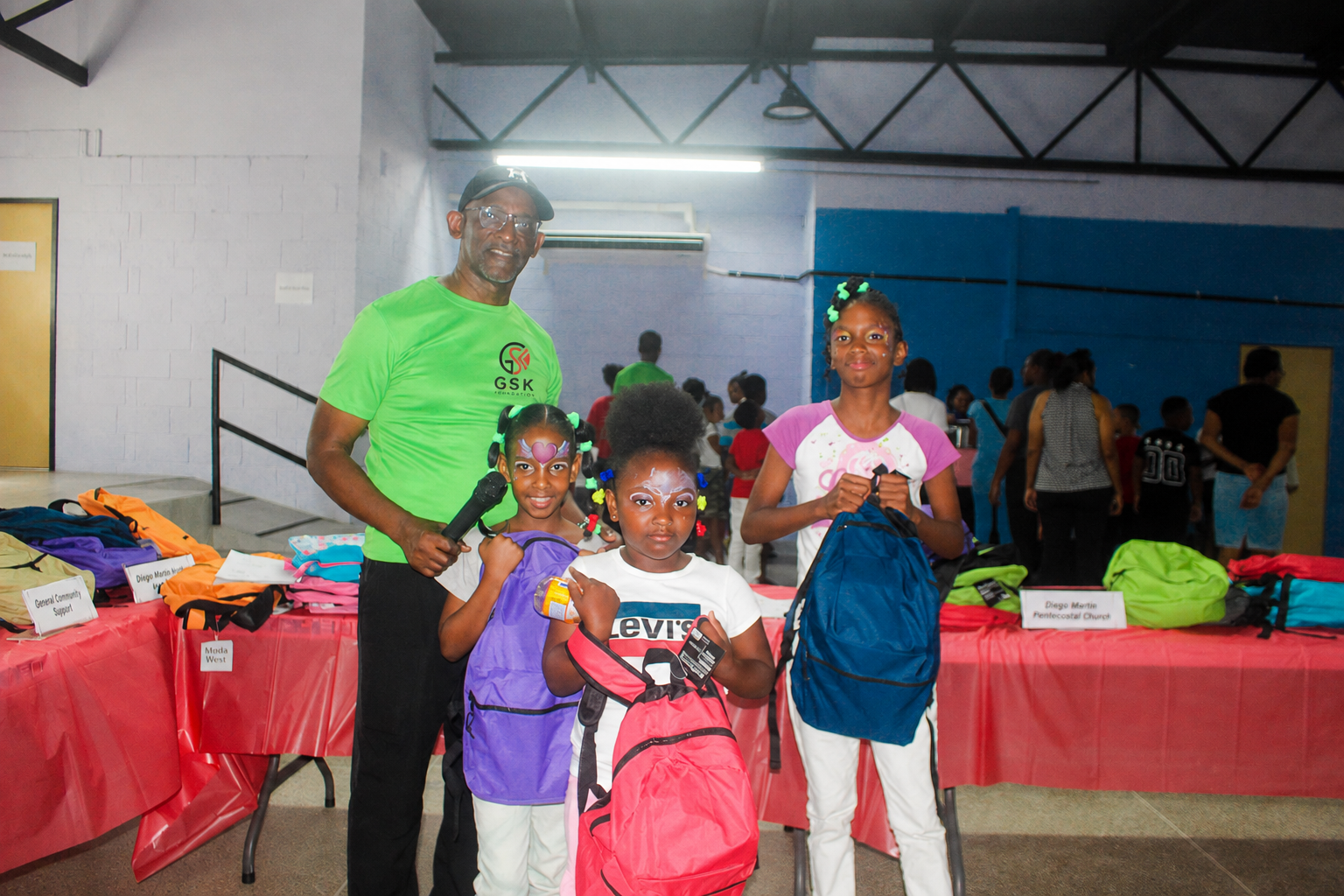 Children with backpacks and a GSK Foundation volunteer at the Trinidad community support event